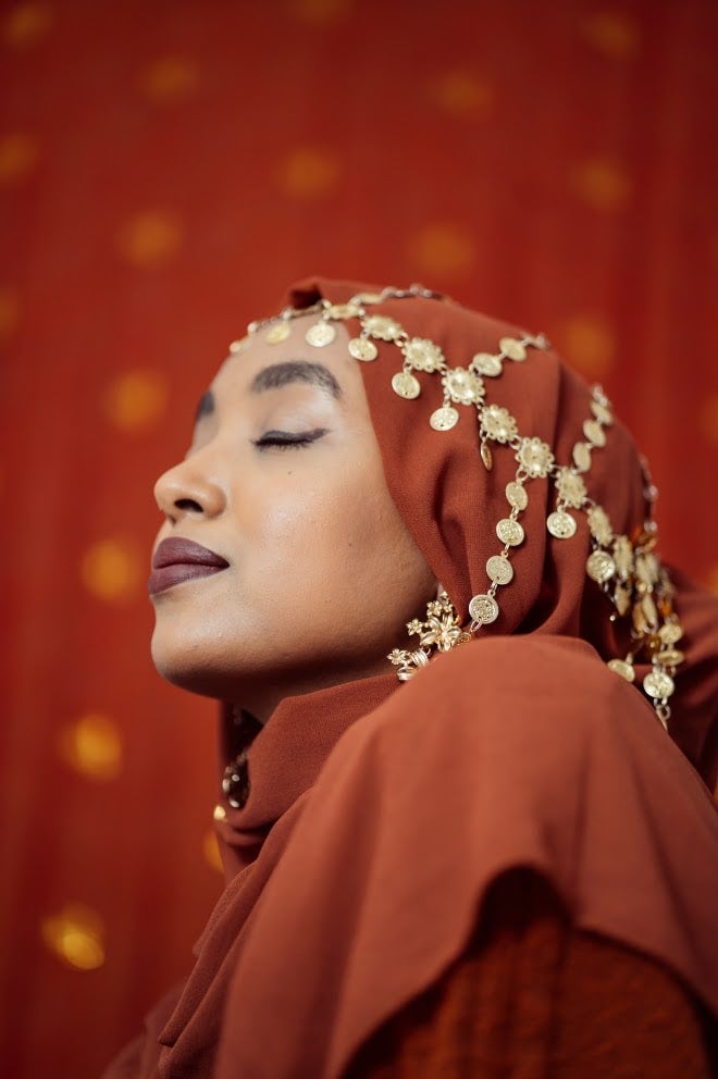 Black Muslim Woman with traditional jewellery headpiece over hijab