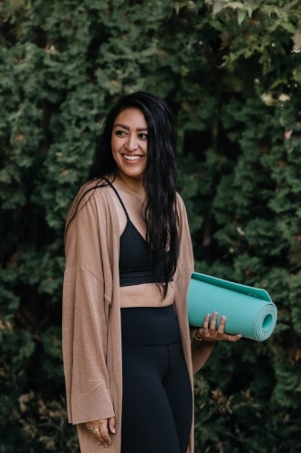 Young adult Filipino woman practicing yoga outdoors at home