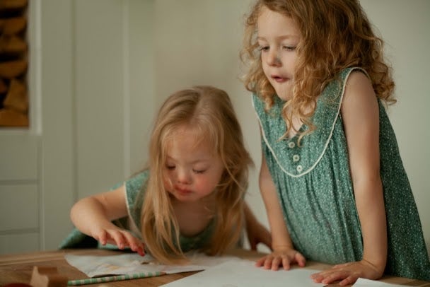 Twin girls with Down Syndrome drawing