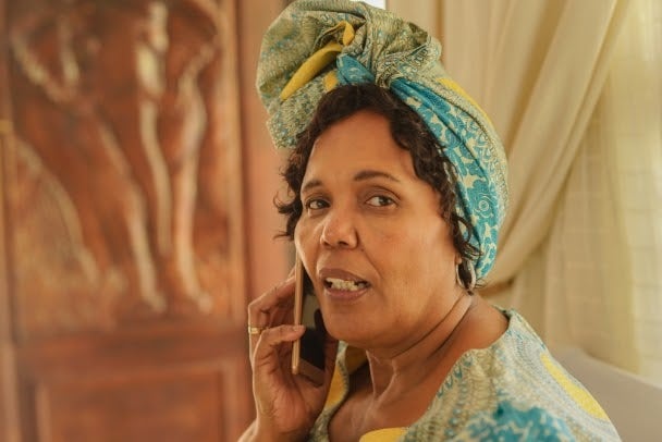 Elderly black woman talking on the phone, photo of older woman talking on phone with head scarf, vintage style