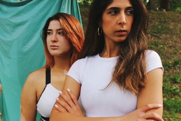 portrait of two women of different skin colors & ethnicity in sports clothing with serious confident face expression