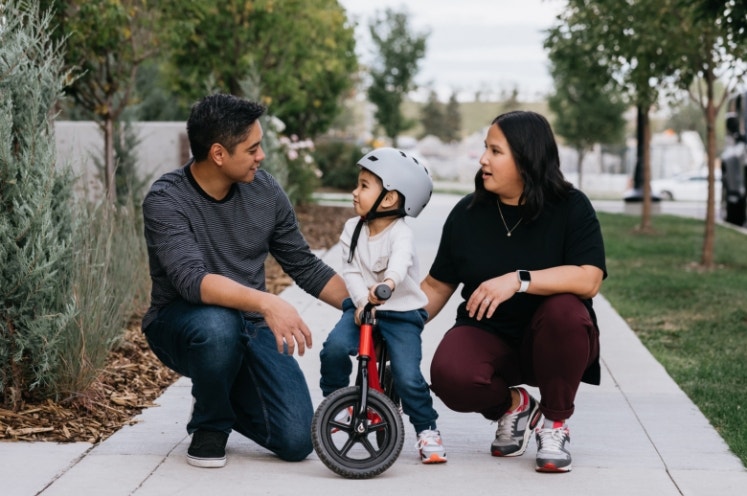 Parents teaching son how to ride a bike