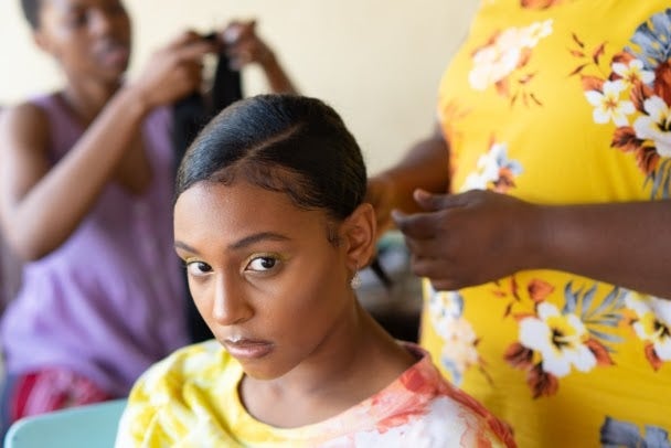 Young black girl getting hair braided