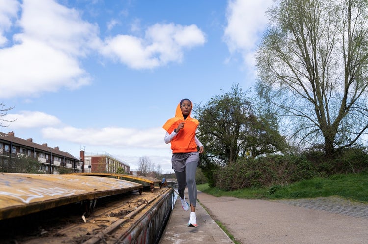 Black Muslim woman runner on the canal