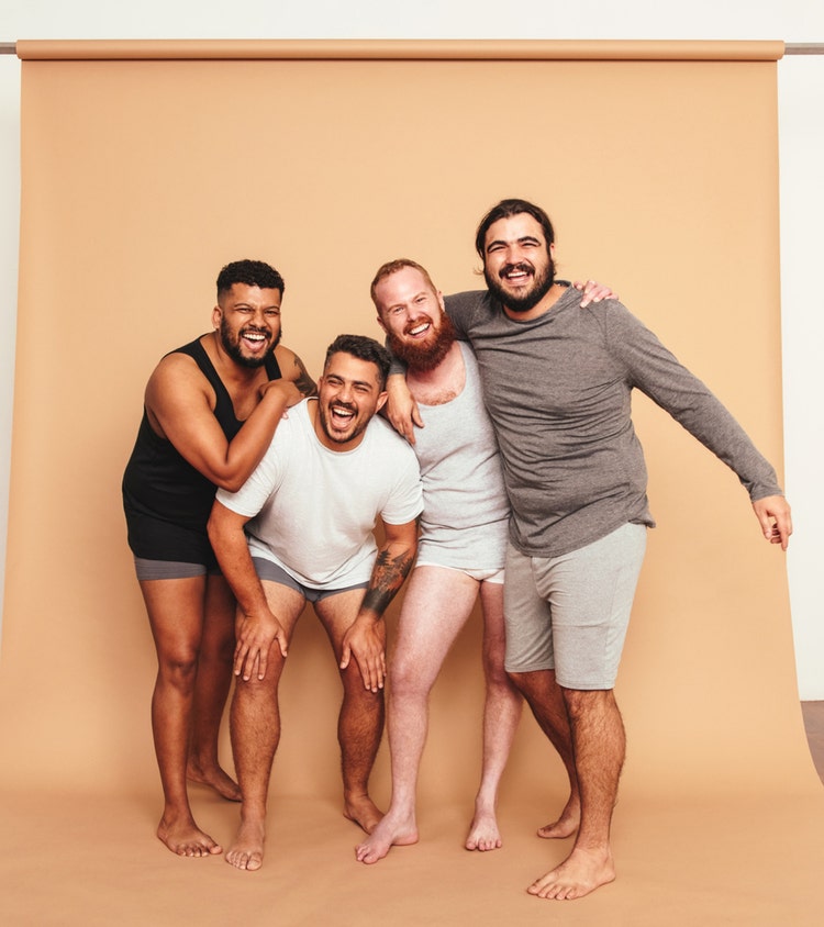 Male friends laughing together in a studio