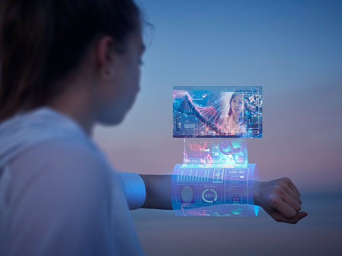 Futuristic augmented reality, connective tech concept. Girl looks at floating screen emerging from holographic smart wrist accessory.