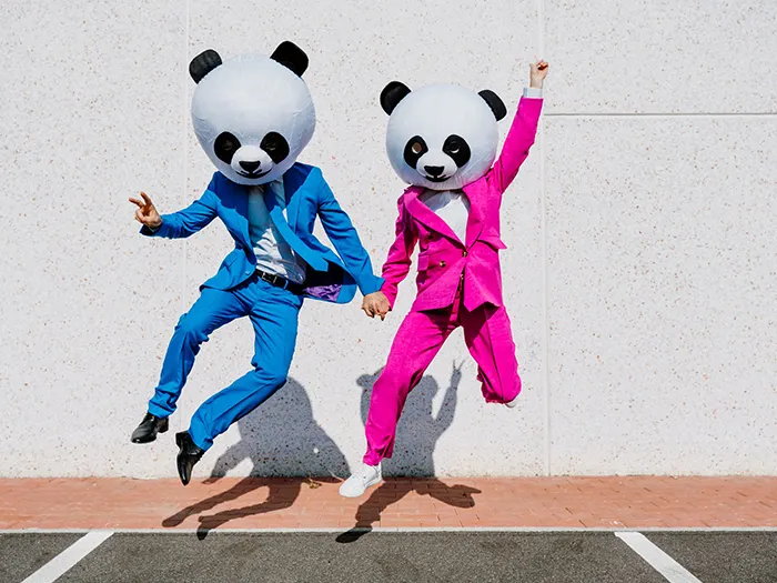 Storytelling image of a couple wearing giant panda head