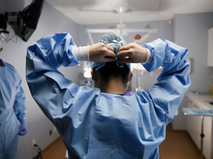 Female surgeon fastening surgical cap in operating room