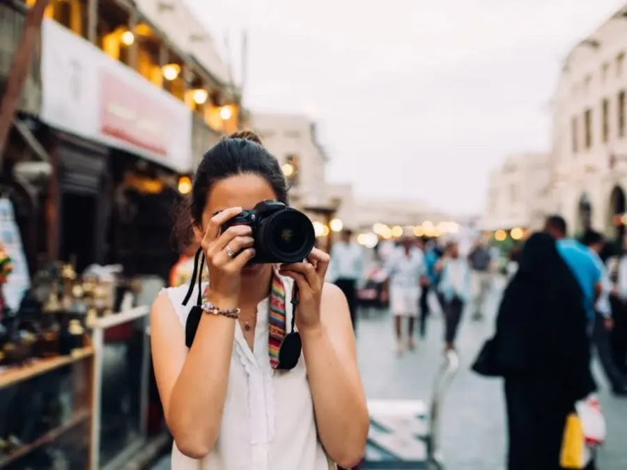 Female photographer taking photos on the street By Photography by Maja Topcagic/Stocksy