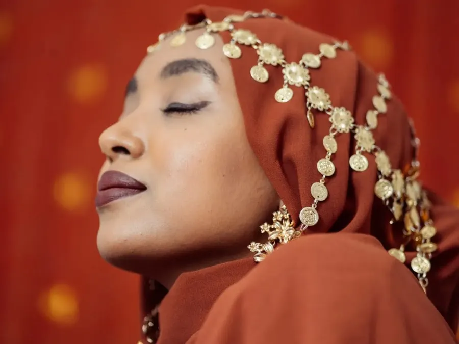Black Muslim Woman with traditional jewellery headpiece over hijab By Amaal Said