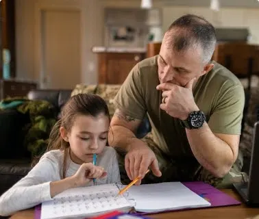 Veteran father helping girl with homework
